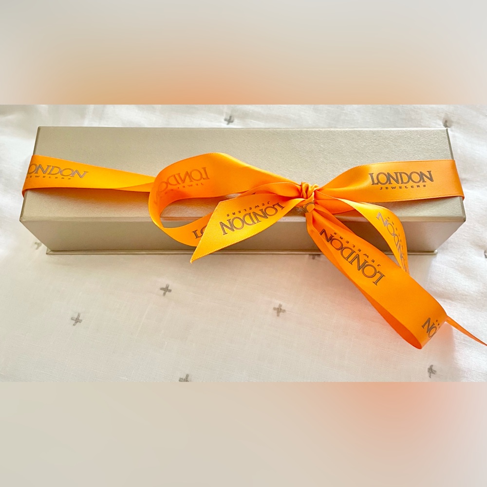 Golden box for a bracelet or watch from London jewelers with satin ribbon
